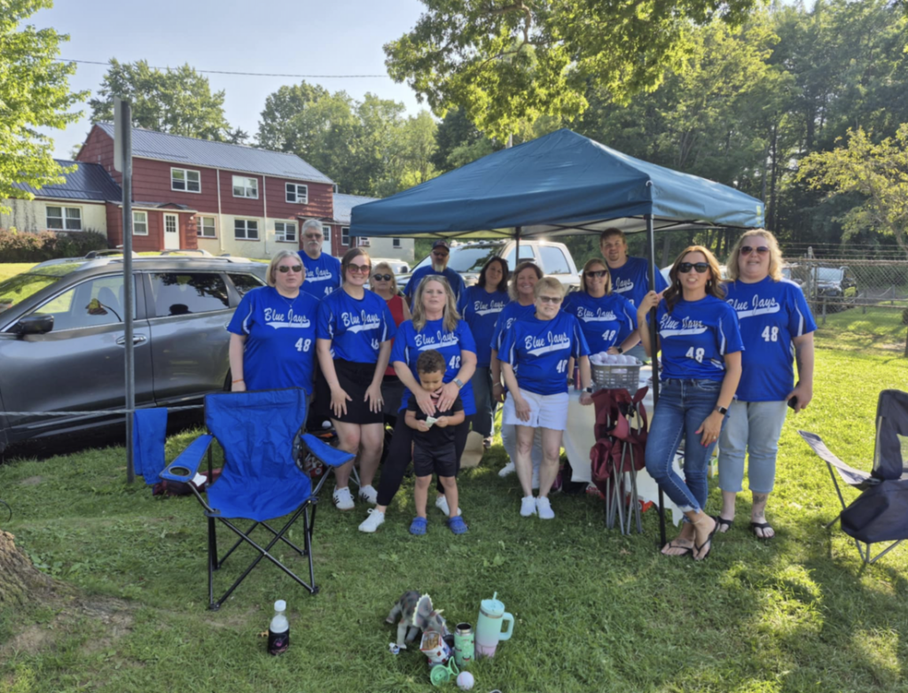 The Blue Jays Babe Ruth League team and supporters in blue Affinity One-sponsored jerseys at the ballpark